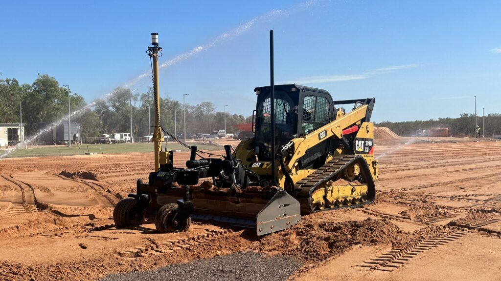 Skid steer on site with water spray
